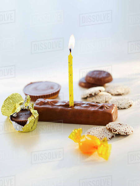Studio shot of chocolate bars with birthday candle - Stock Photo - Dissolve