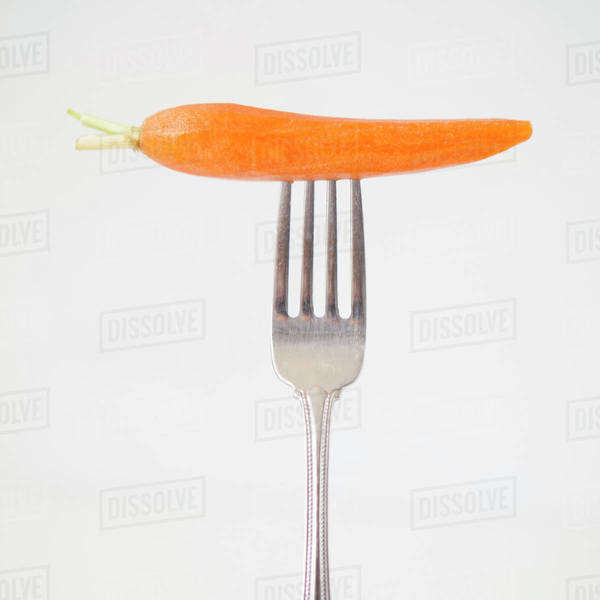 Carrot on fork, studio shot Stock Photo Dissolve
