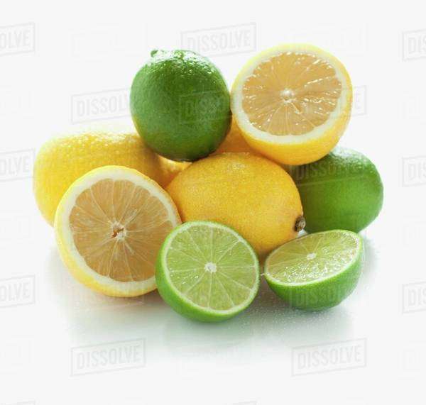 A pile of limes and lemons, whole and halved Stock Photo Dissolve