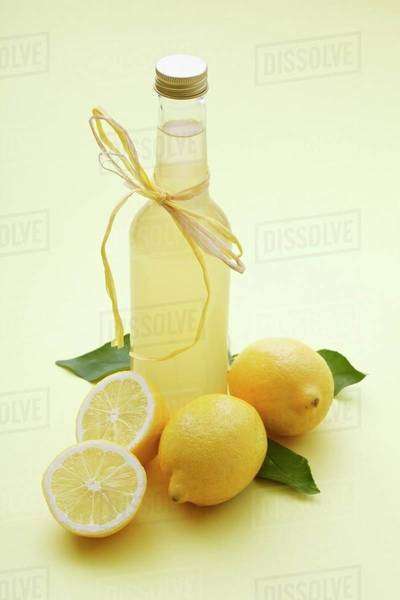 A bottle of lemonade and fresh lemons - Stock Photo - Dissolve