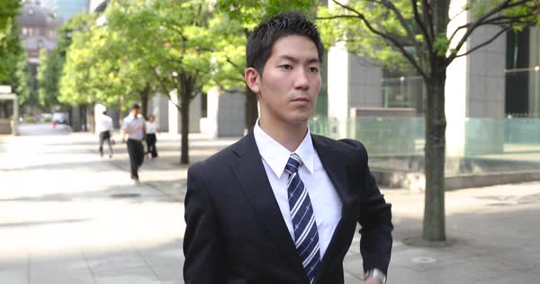 Young Japanese office worker walking in business district, Tokyo, Japan ...