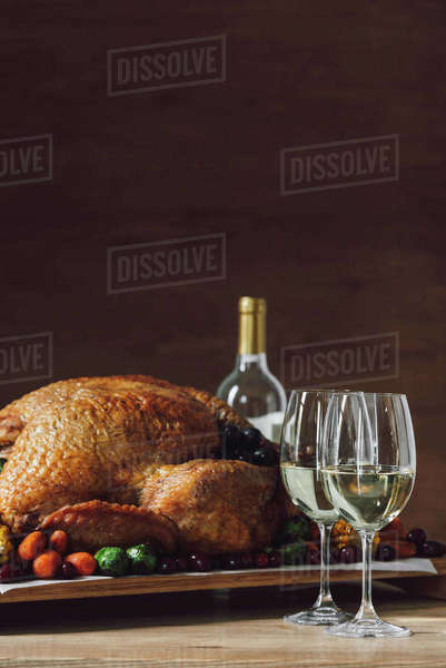 Close up view of traditional roasted turkey, vegetables and glasses of