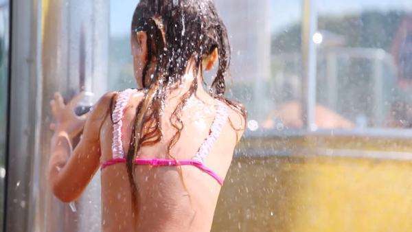 Nice little girl washes under water in shower cabin - Stock Video Footage - Dissolve