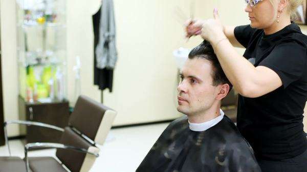Hairdresser Cuts Hair Of Man With Long Hair With Scissors Stock
