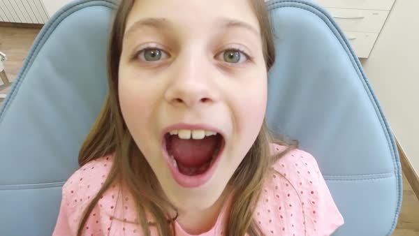 Close-up of an open mouth of a little girl at dentist