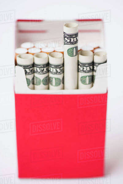Cigarette pack containing rolled dollars - Stock Photo - Dissolve