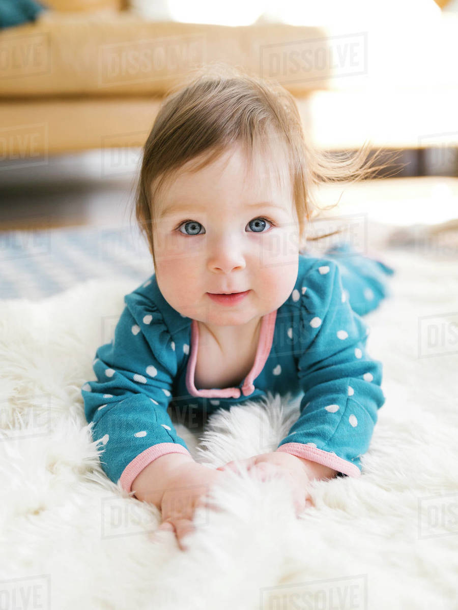 Baby girl lying on rug Stock Photo Dissolve