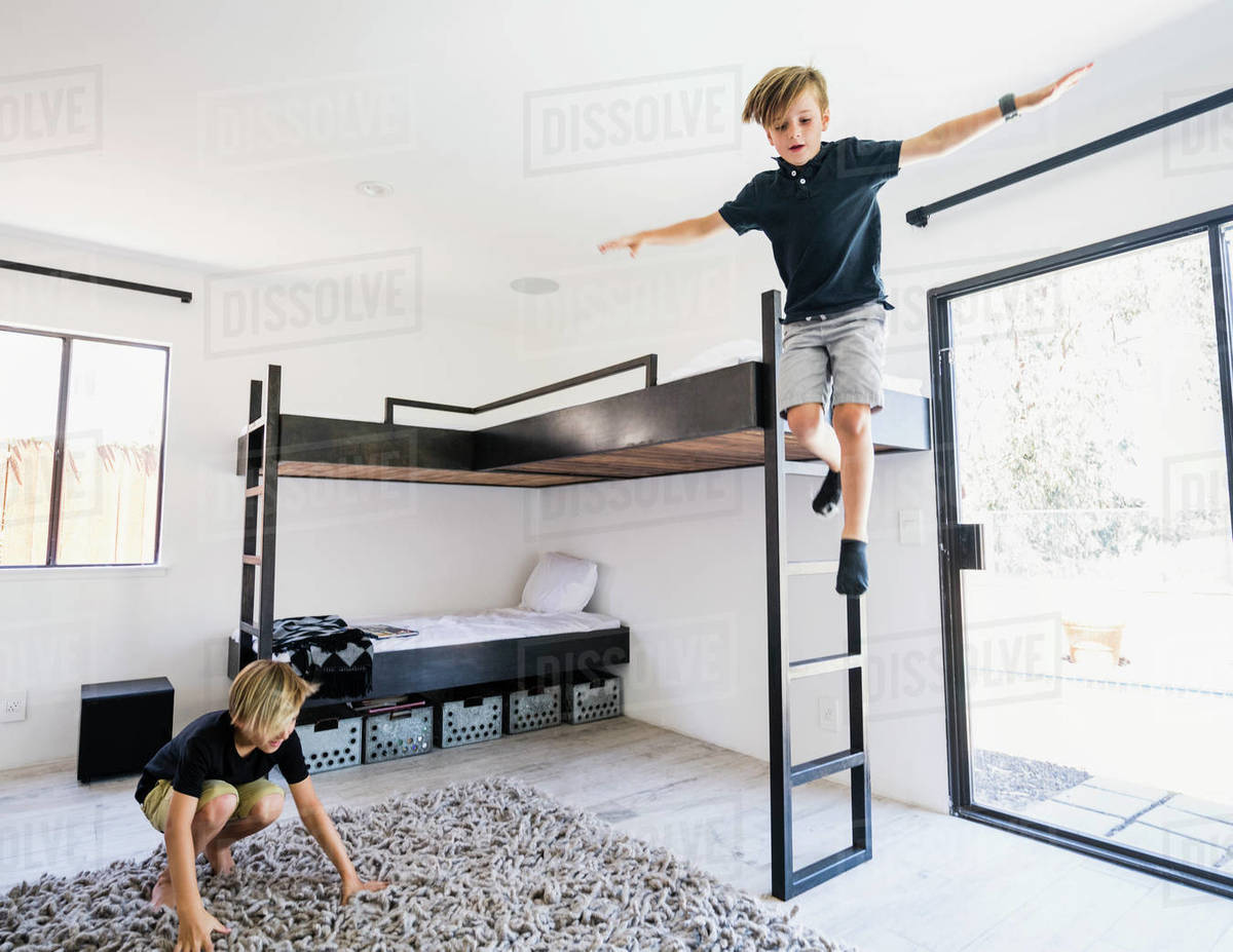Boy jumping off bunk bed Stock Photo Dissolve