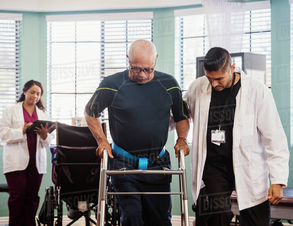 Senior man exercising with therapists during physical therapy Royalty-free stock photo