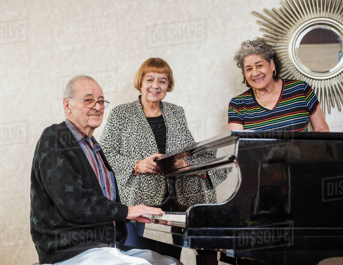 Senior women listening to man playing piano Royalty-free stock photo