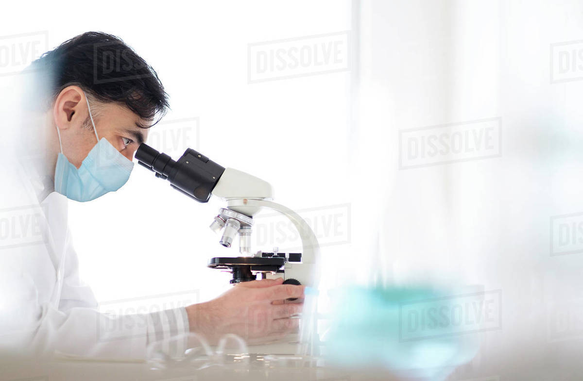 Doctor using microscope Stock Photo Dissolve