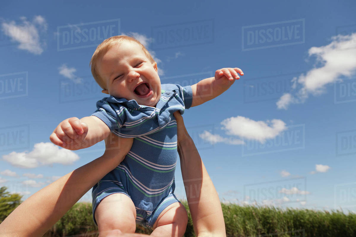 Caucasian mother lifting baby boy Stock Photo Dissolve
