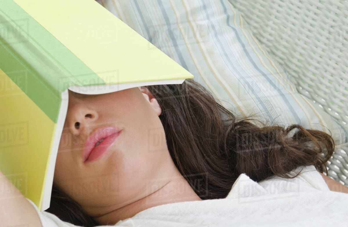 Woman sleeping with book on face Stock Photo Dissolve