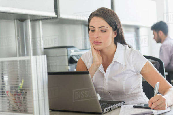Woman working in office, man in background - Royalty-free Stock Photo ...