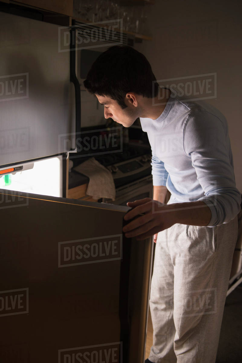 Man opening fridge at night Stock Photo Dissolve