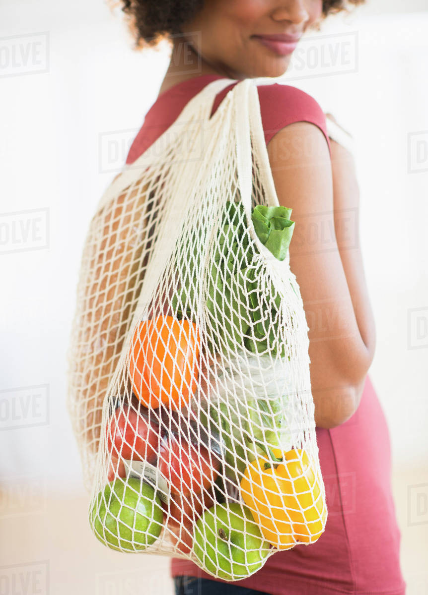 Woman carrying grocery bag Stock Photo Dissolve