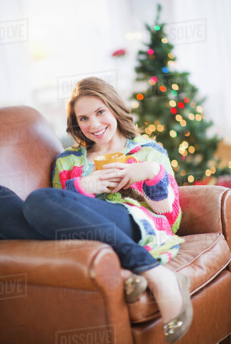 Young woman relaxing on sofa Stock Photo Dissolve