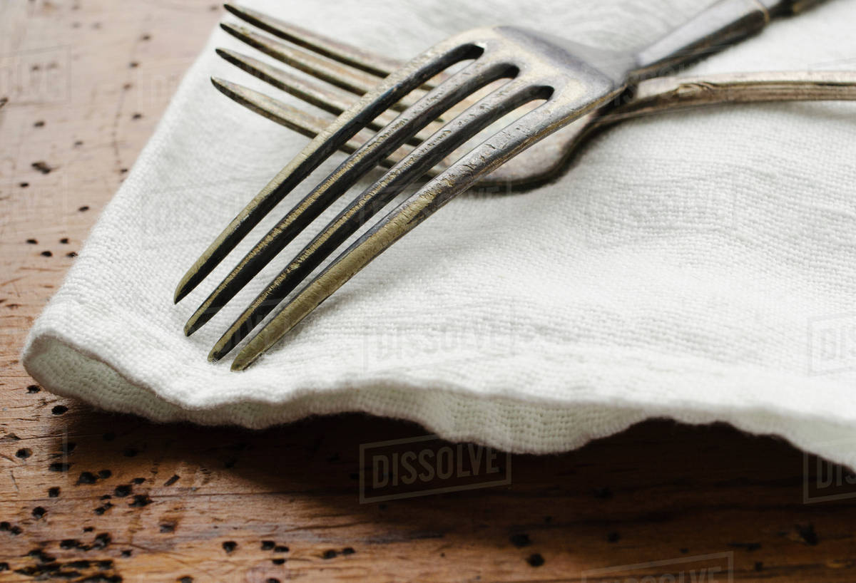 Two forks on napkin Stock Photo Dissolve