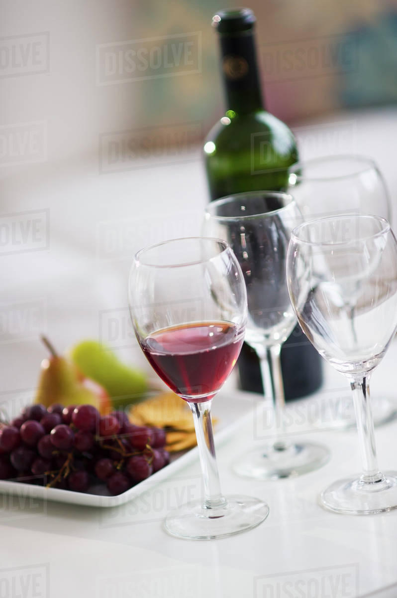 Wine glasses and fruits on table Stock Photo Dissolve