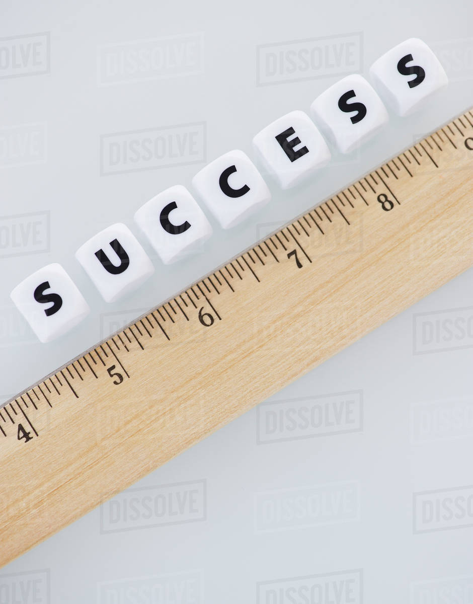 Studio shot of ruler and dice spelling out success Stock Photo Dissolve