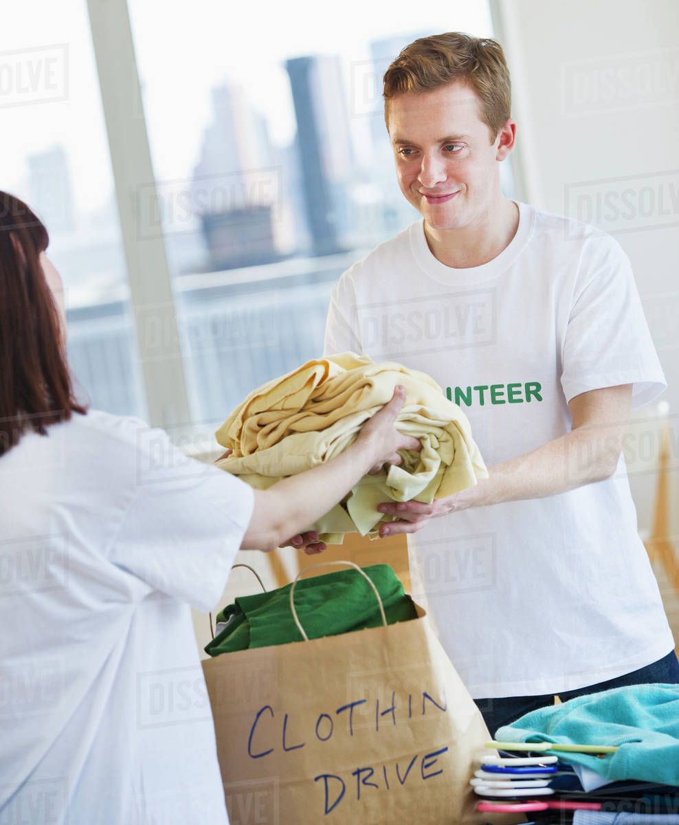 Volunteers organizing clothing drive Stock Photo Dissolve