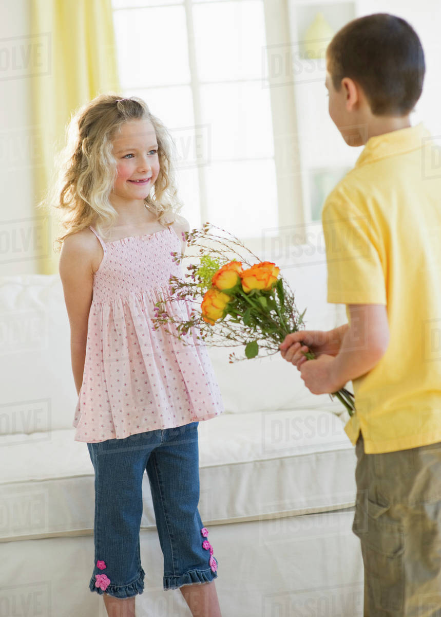 Young boy giving flowers to young girl Stock Photo Dissolve