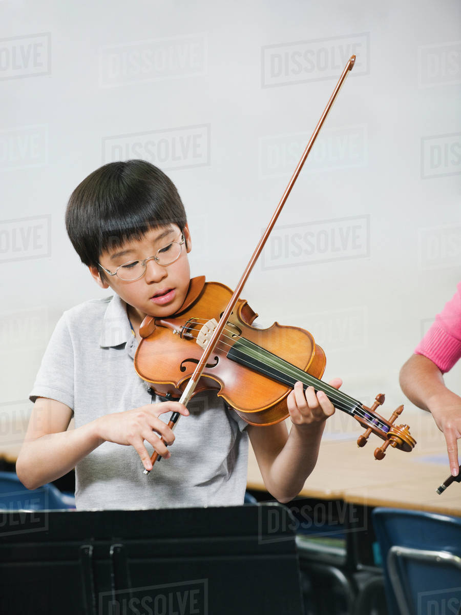 Elementary school students playing instruments in music class Stock