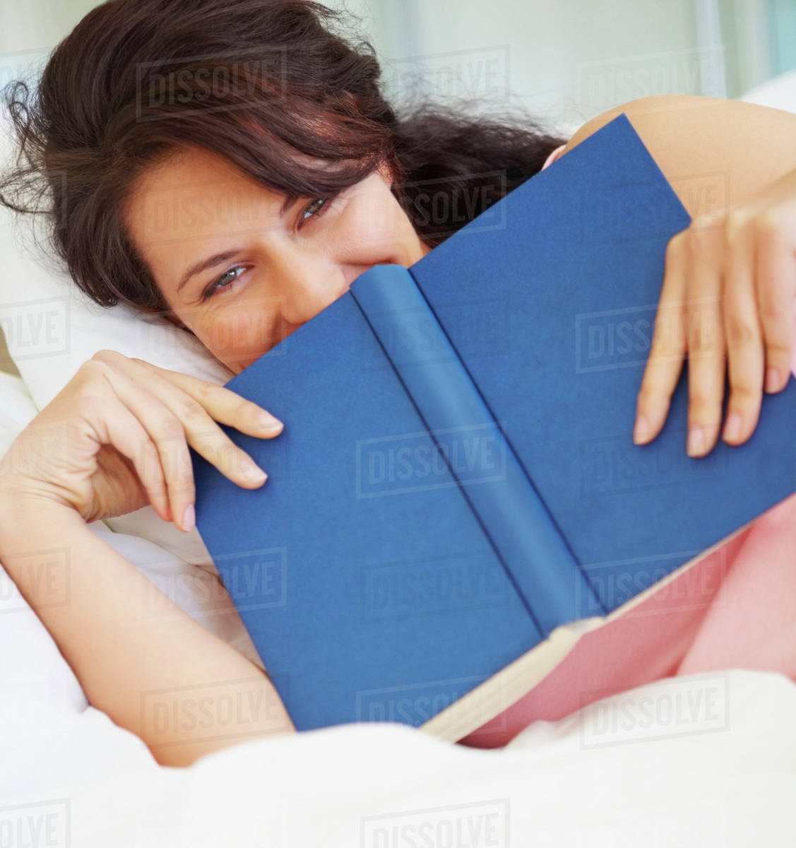 Woman reading in bed Stock Photo Dissolve