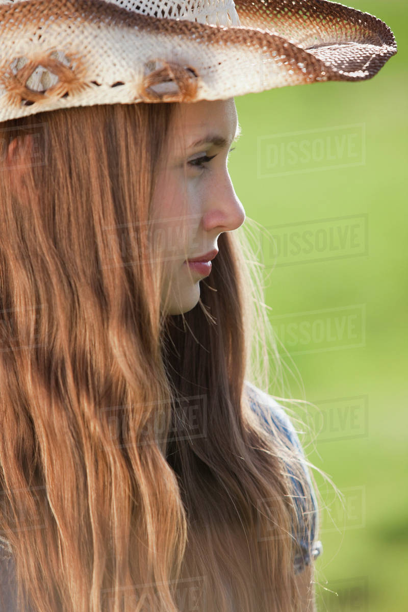 Side Profile Of A Beautiful Long Haired Cowgirl Stock Photo