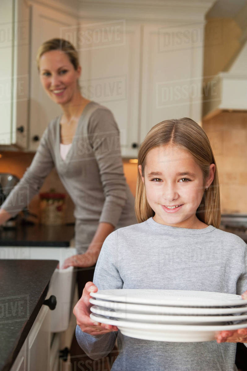 Girl holding plates Stock Photo Dissolve