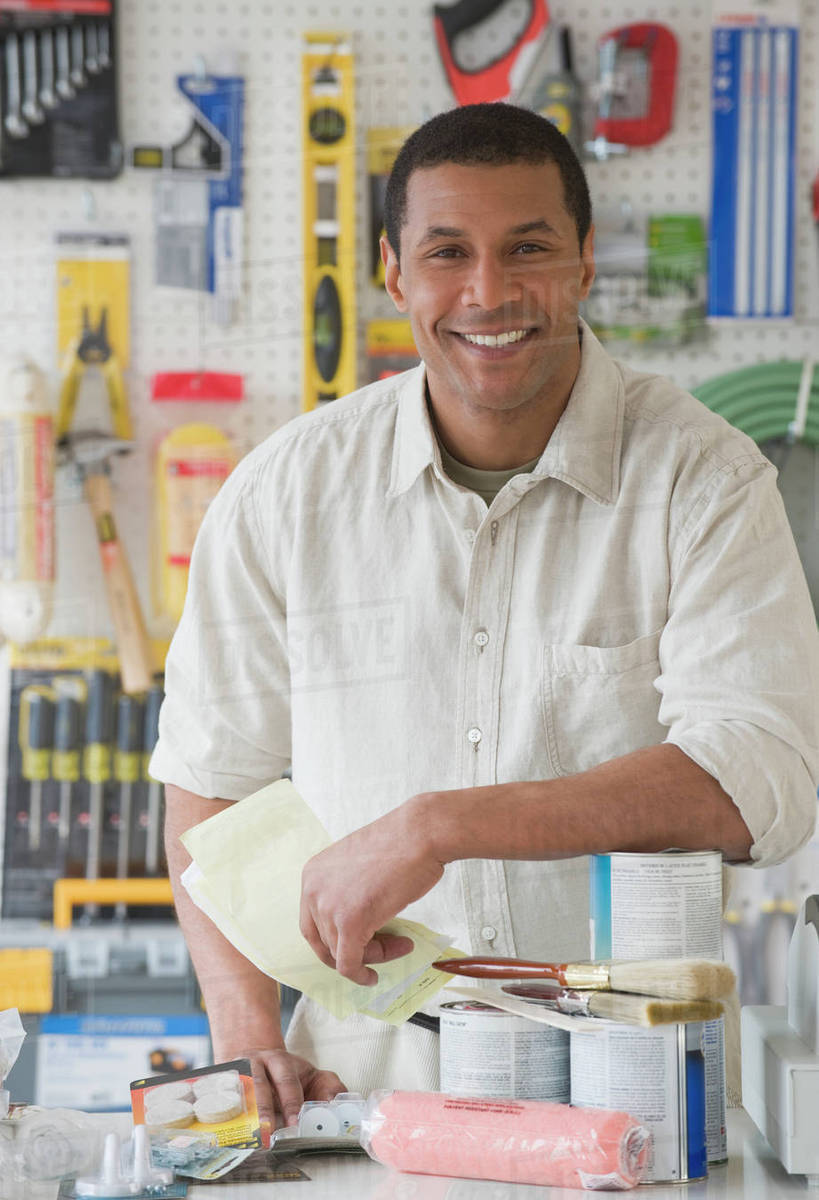 African sales clerk behind counter at hardware store Stock Photo
