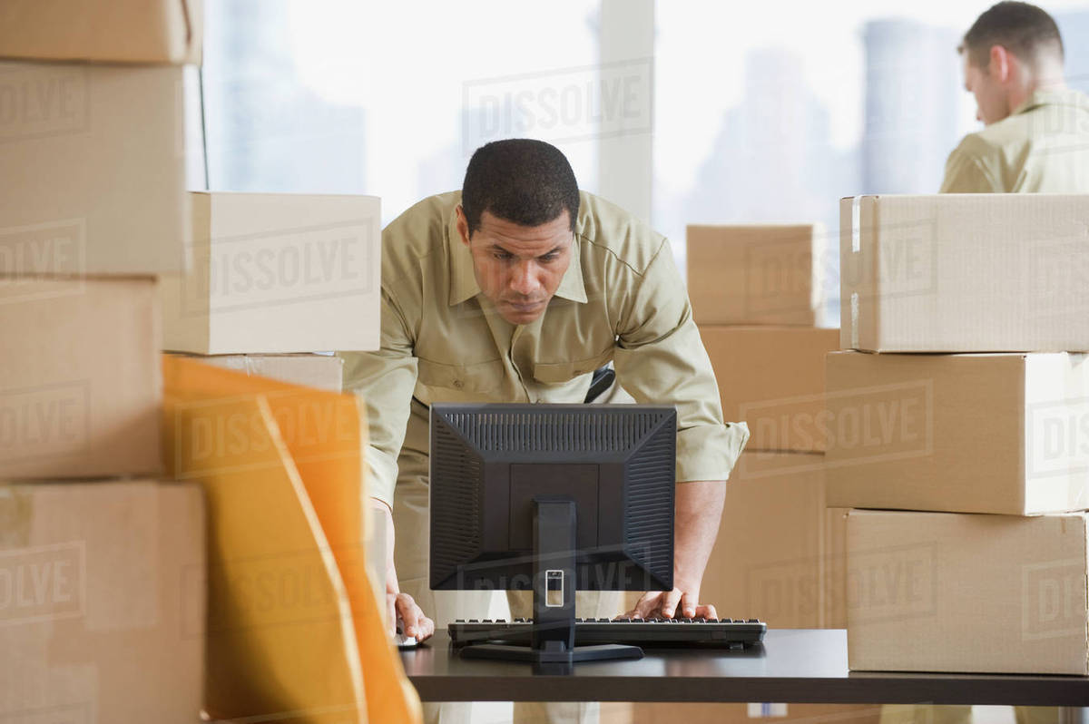 African delivery man looking at computer - Royalty-free Stock Photo ...