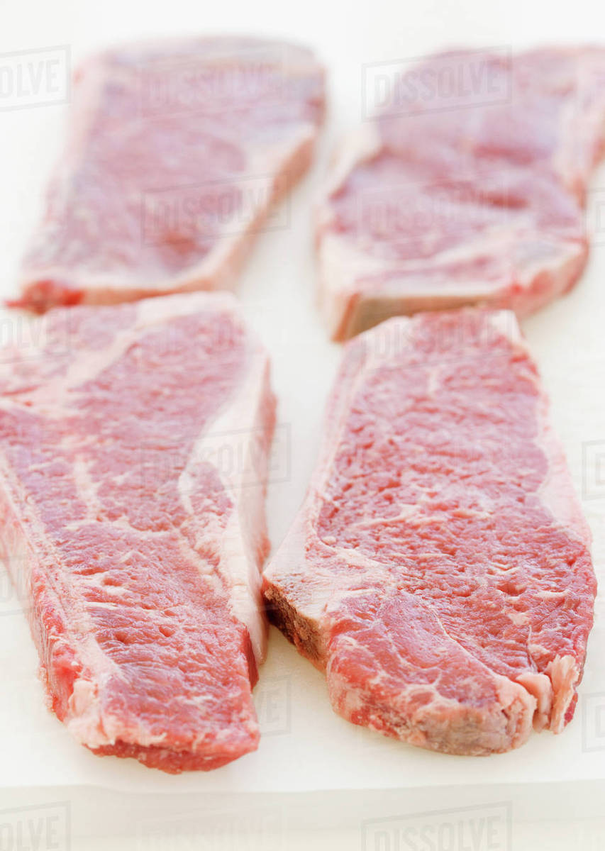 Close up of raw steaks Stock Photo Dissolve