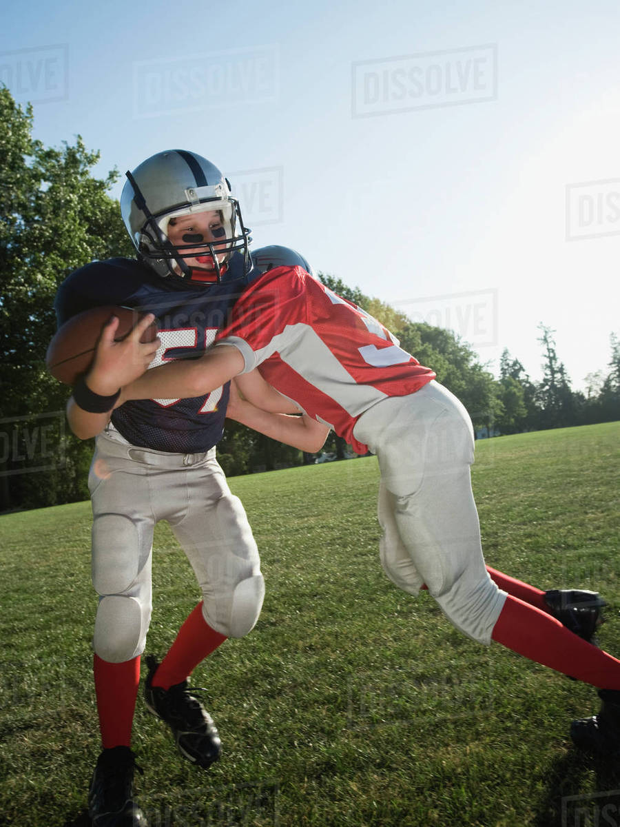Football player tackling opponent Stock Photo Dissolve