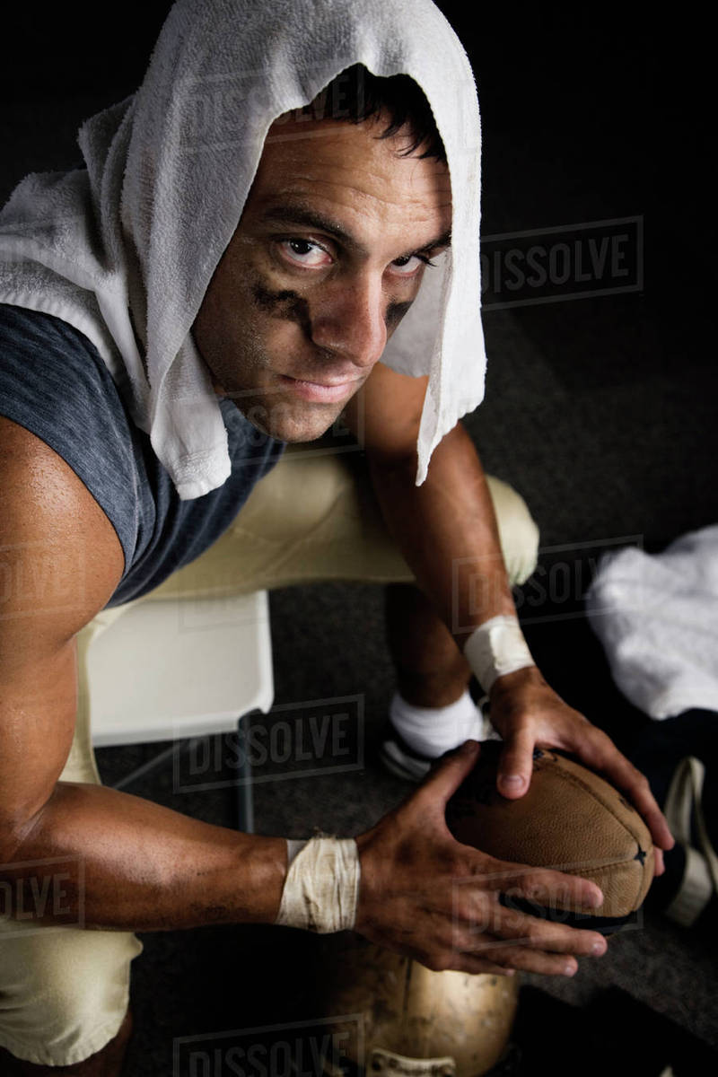 Football player with towel on head holding football Stock Photo