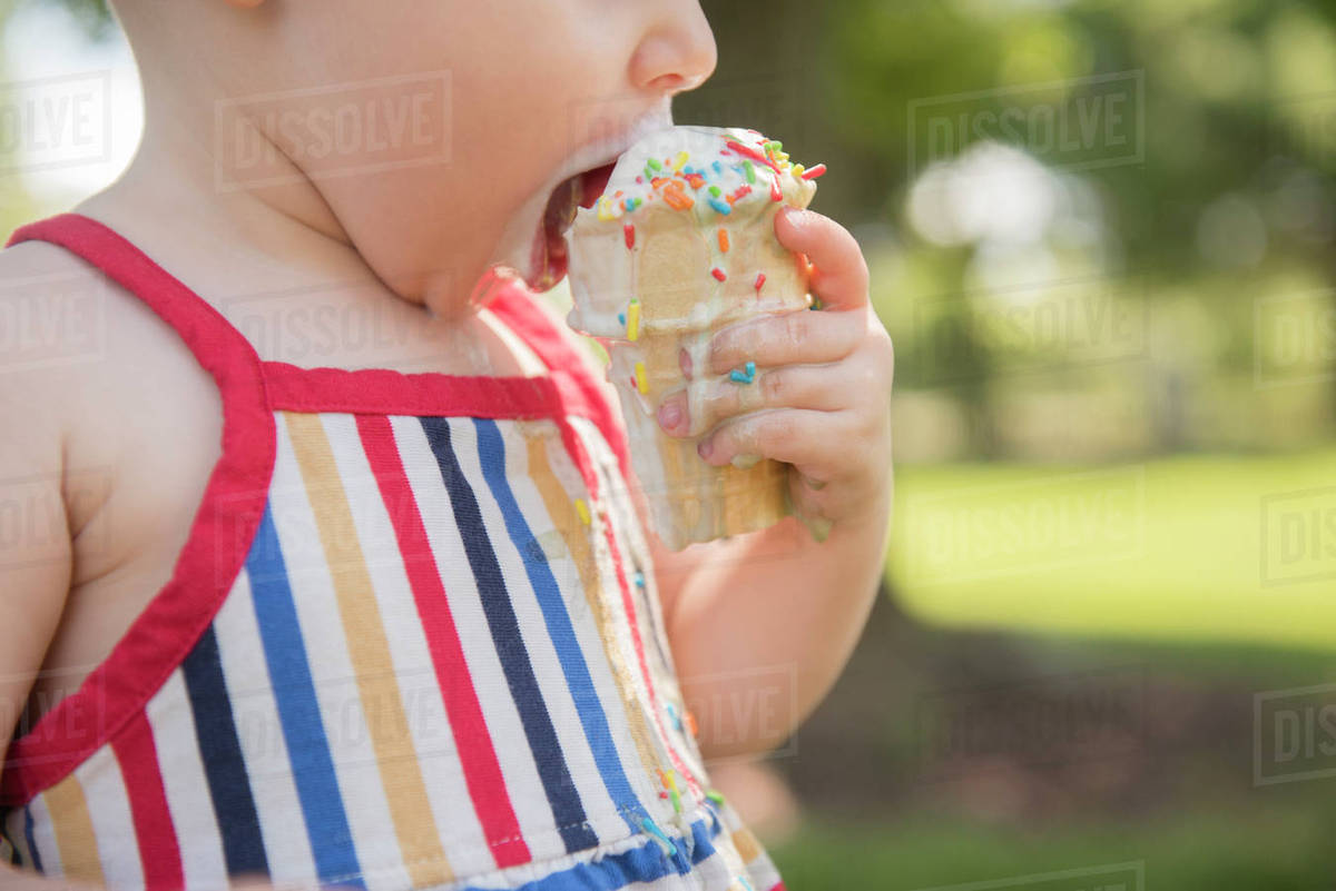 Baby girl (1823 months) eating icecream Stock Photo Dissolve