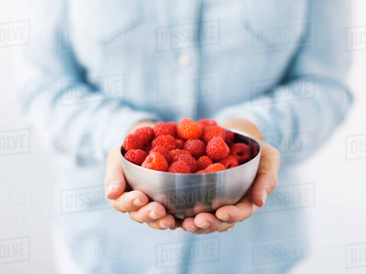 Mid section of Mature woman holding bowl with raspberries - Stock Photo ...