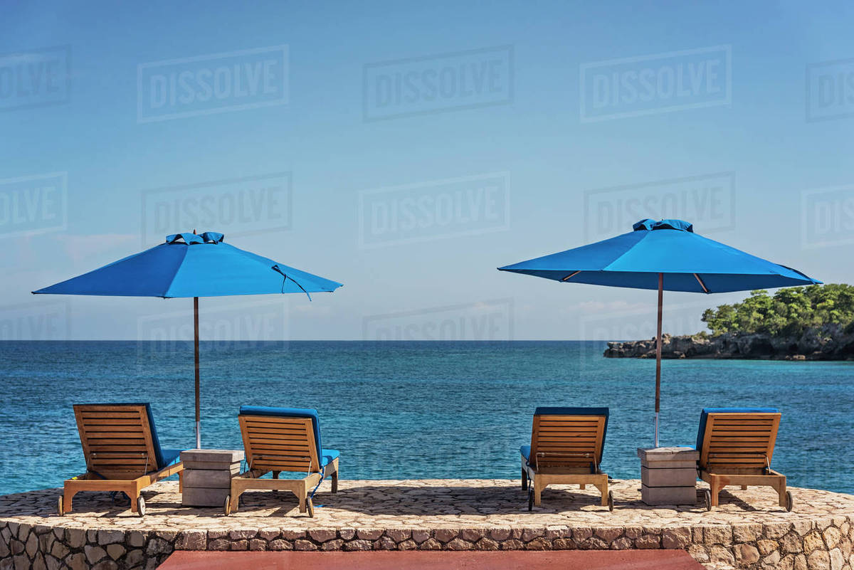 Jamaica Negril Beach Umbrellas And Lounge Chairs Against Tranquil Jamaica Negril Beach Umbrellas And Lounge Chairs Against Tranquil Seascape