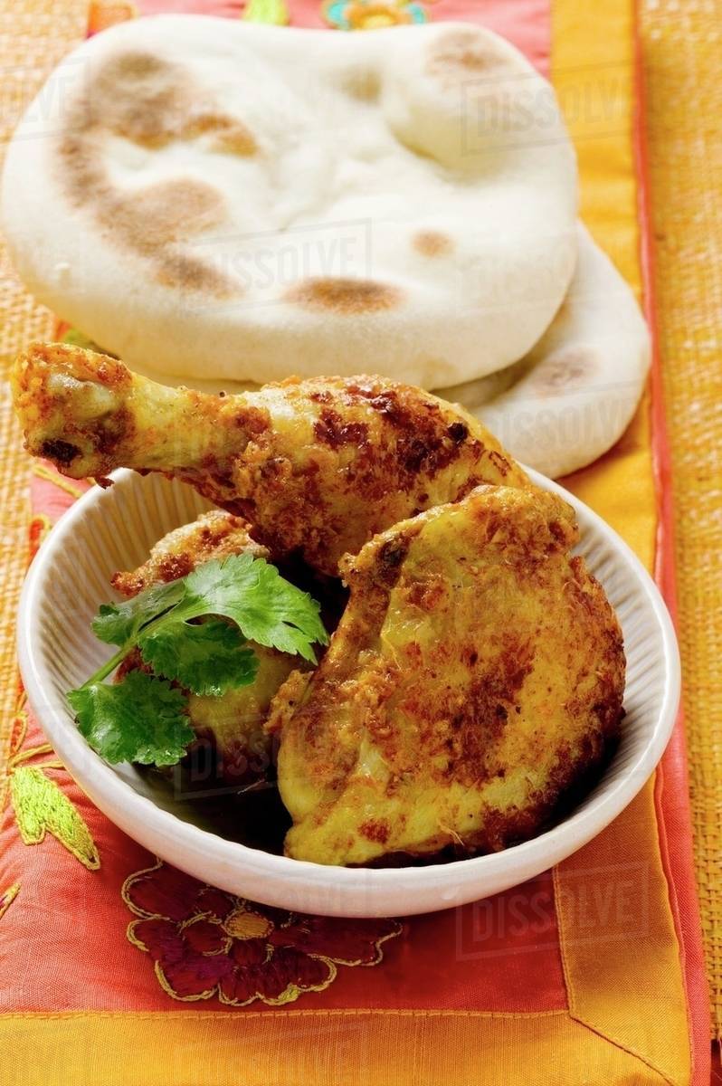 Spicy Tandoori chicken with flatbread (India) Stock Photo Dissolve