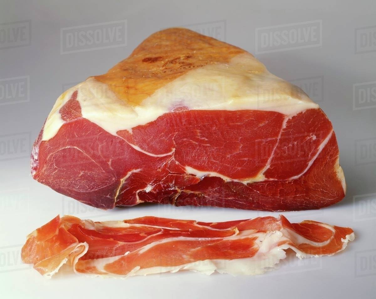 Parma ham on the joint and sliced Stock Photo Dissolve