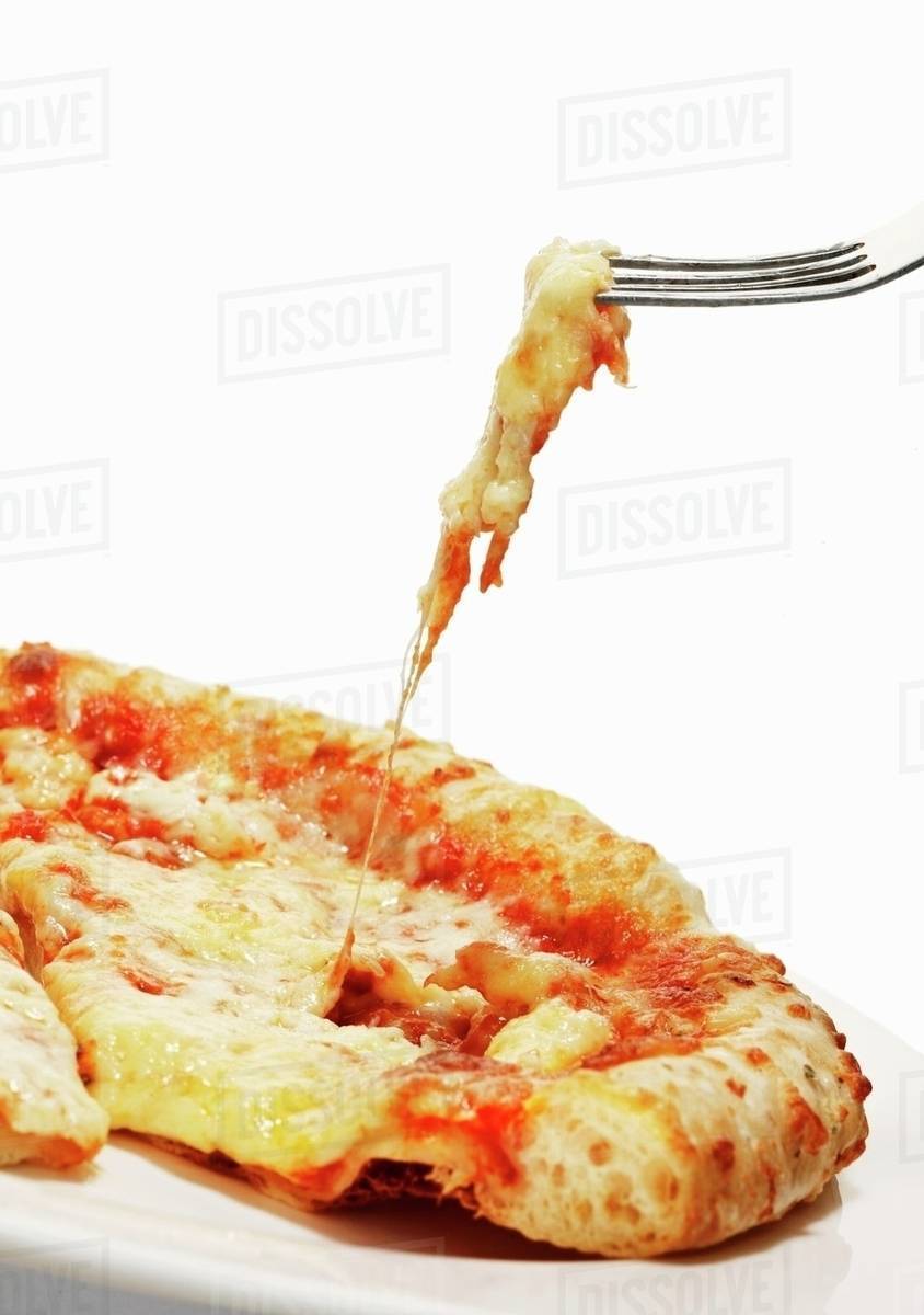 A slice of pizza with cheese strings on a fork Stock Photo Dissolve