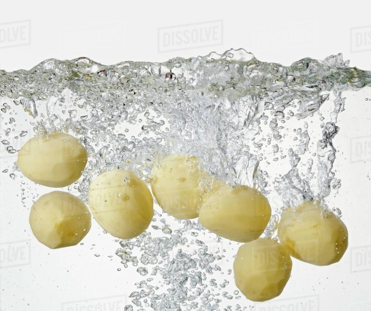Peeled potatoes in boiling water Stock Photo Dissolve