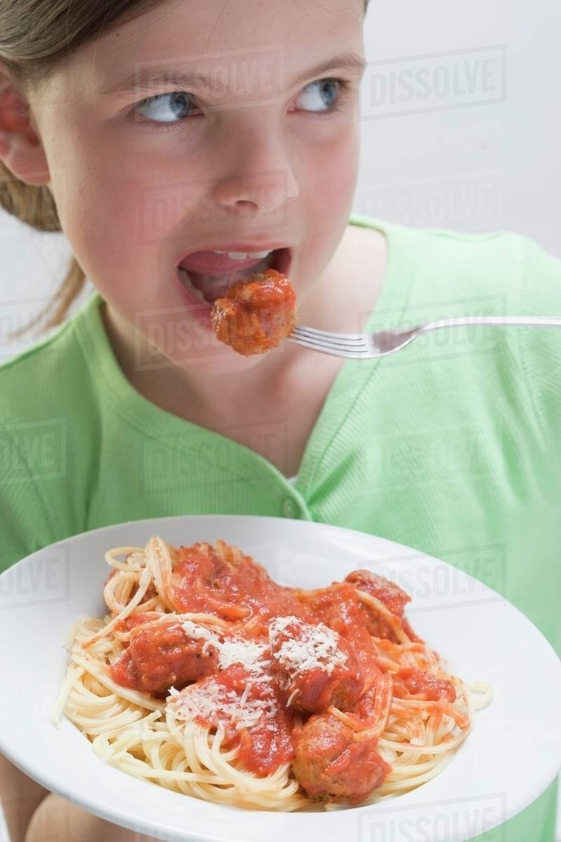Girl eating spaghetti with meatballs Stock Photo Dissolve