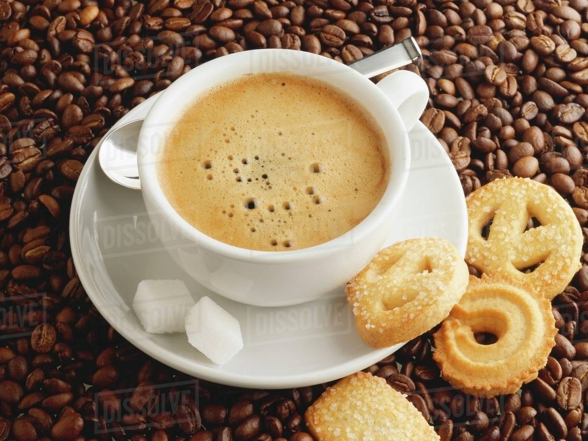 A cup of coffee with sugar cubes and biscuits Stock Photo Dissolve