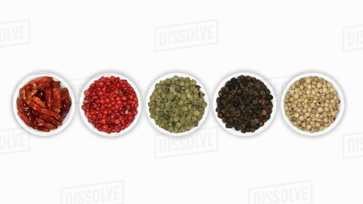 Four different types of peppercorns and dried chillies Stock Photo