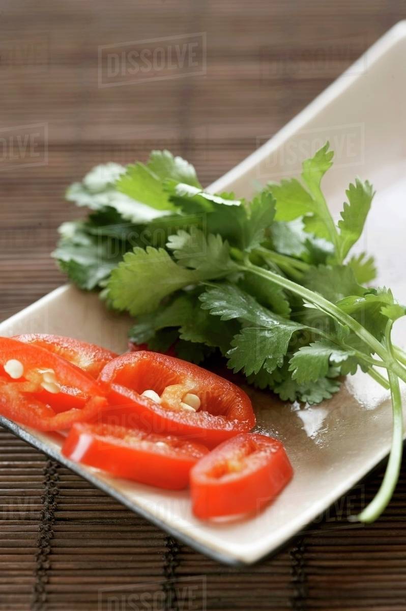 Sliced chilli and coriander leaves in a dish Stock Photo Dissolve