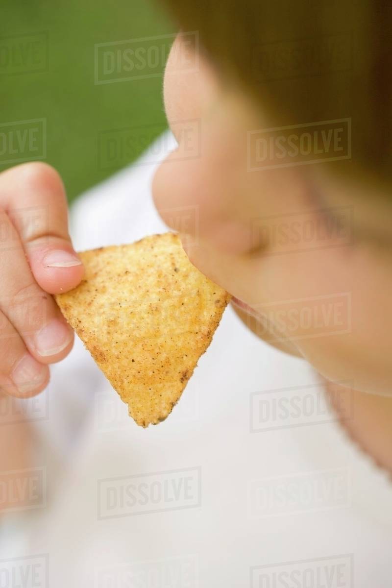 Child eating tortilla chip Stock Photo Dissolve