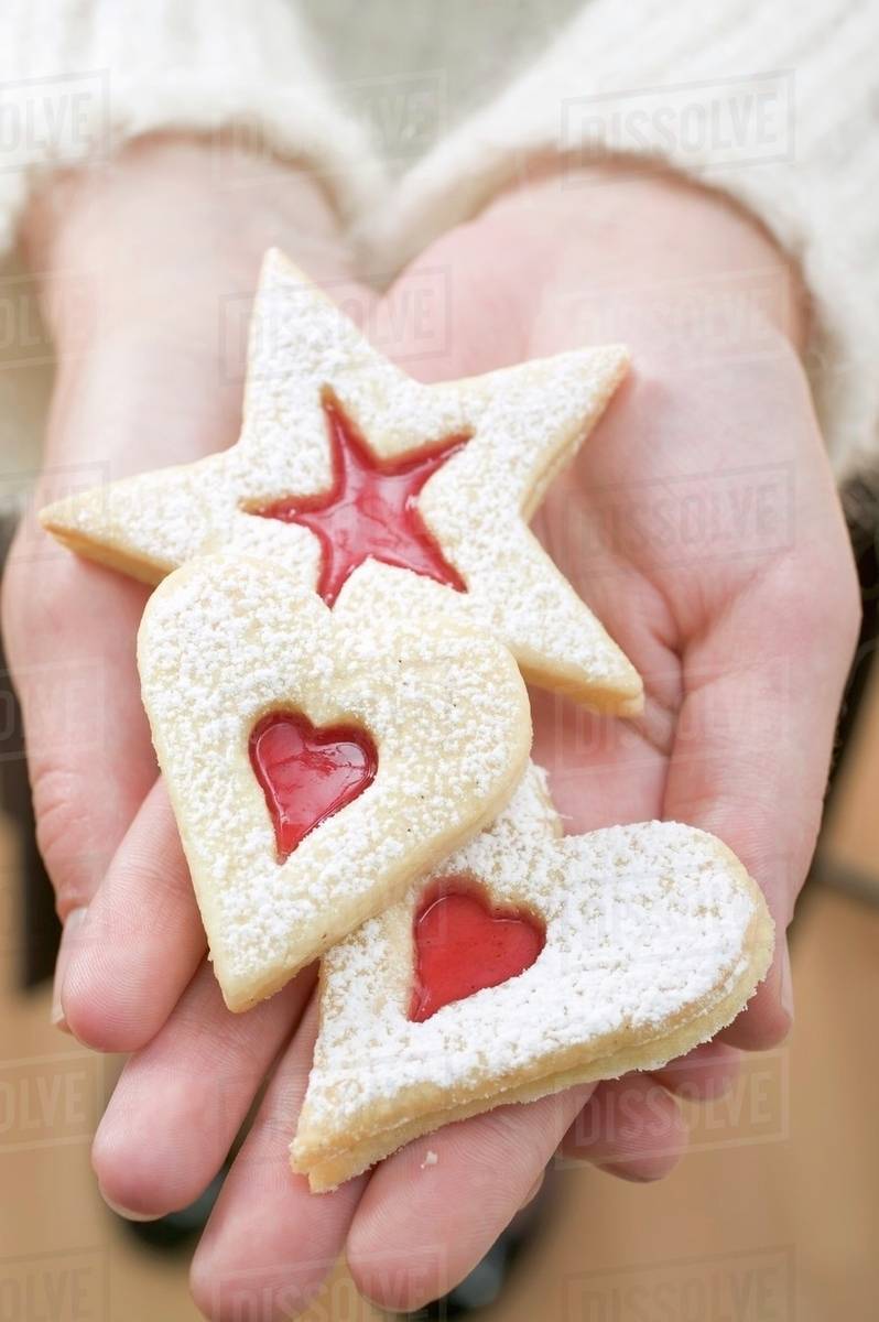 Hands holding three jam biscuits Stock Photo Dissolve