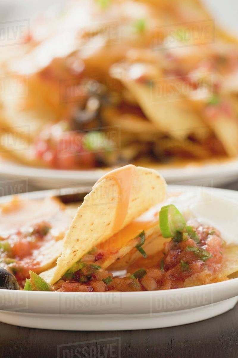Tortilla chips with melted cheese, olives and sour cream Stock Photo