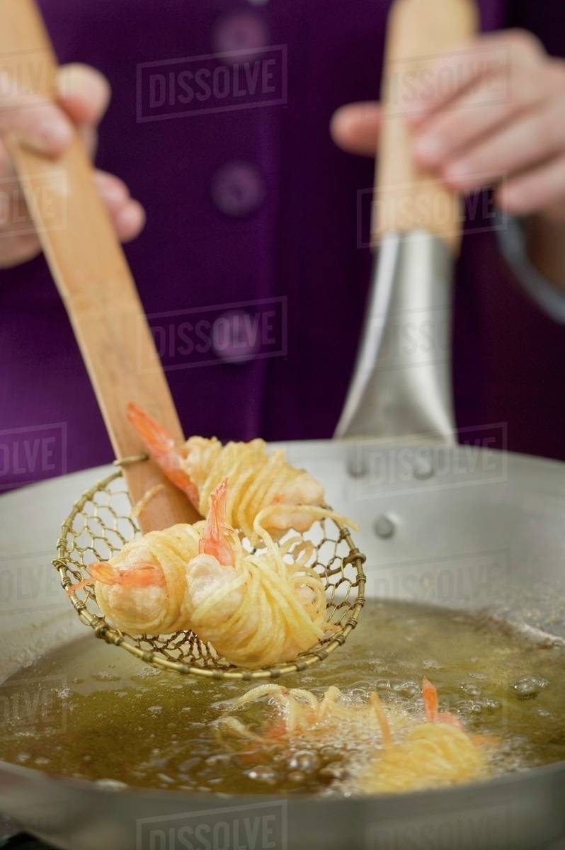 Deepfrying noodlewrapped prawns in wok Stock Photo Dissolve